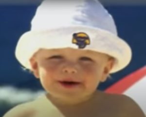 A baby wearing a Banana Boat hat.