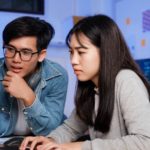 How Has Technology Changed Teaching & Learning Banner Image - Programmer and developer teamwork working in a software development and coding technologies at night.