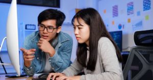 How Has Technology Changed Teaching & Learning Banner Image - Programmer and developer teamwork working in a software development and coding technologies at night.