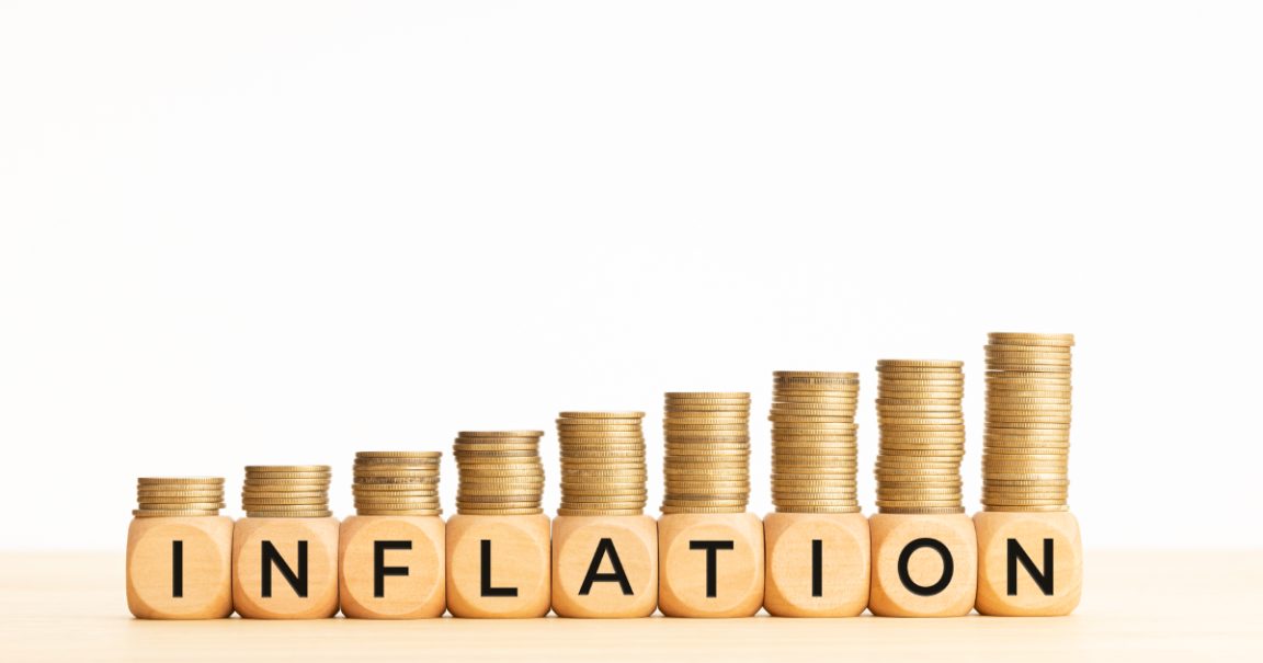 Inflation concept. Text on wooden blocks and stacked coins. Copy space