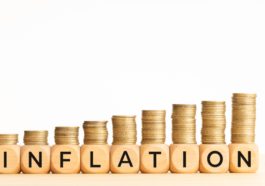 Inflation concept. Text on wooden blocks and stacked coins. Copy space