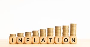 Inflation concept. Text on wooden blocks and stacked coins. Copy space