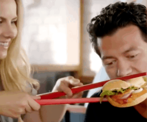 white guy eating a burger with chopsticks