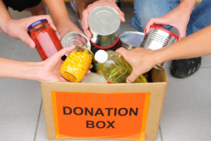 hands placing food into donation box