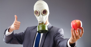 man with gasmask holding apple
