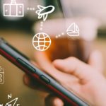 Travel vacation icons mixed screen on woman hand using smartphon