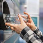 A man placing bottle into recycling machine