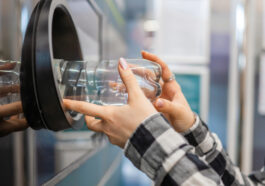 A man placing bottle into recycling machine