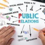 Public Relations concept. Chart with keywords and icons. Hands on working desk doing business