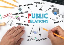 Public Relations concept. Chart with keywords and icons. Hands on working desk doing business