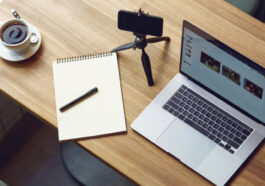 top view of a table with laptop, smartphone, notebook and a cup of coffee on it