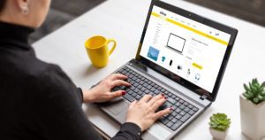 Woman shopping online with laptop computer from home. Modern flat design e-commerce web site with technology products