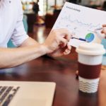 Business people having meeting in cafe and discussing document with website visitors activity