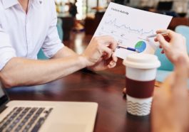 Business people having meeting in cafe and discussing document with website visitors activity