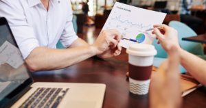 Business people having meeting in cafe and discussing document with website visitors activity