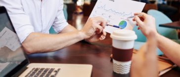 Business people having meeting in cafe and discussing document with website visitors activity