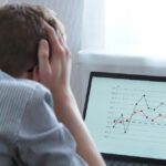 A frustrated man looking at the chart on his laptop