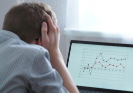 A frustrated man looking at the chart on his laptop