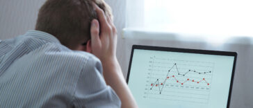 A frustrated man looking at the chart on his laptop