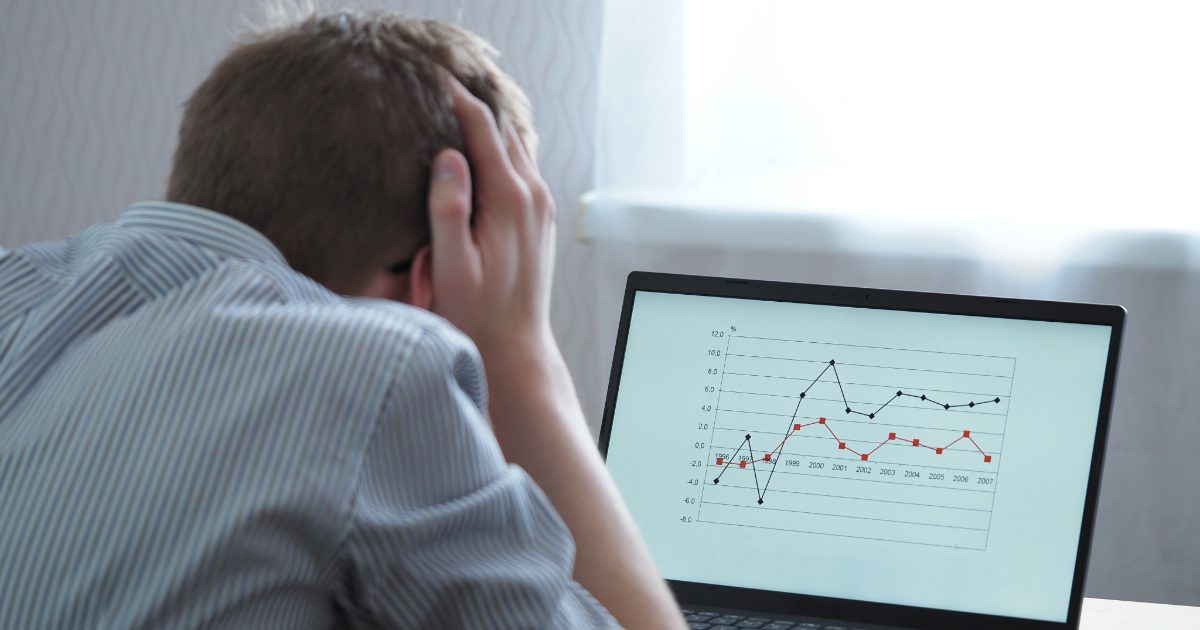 A frustrated man looking at the chart on his laptop